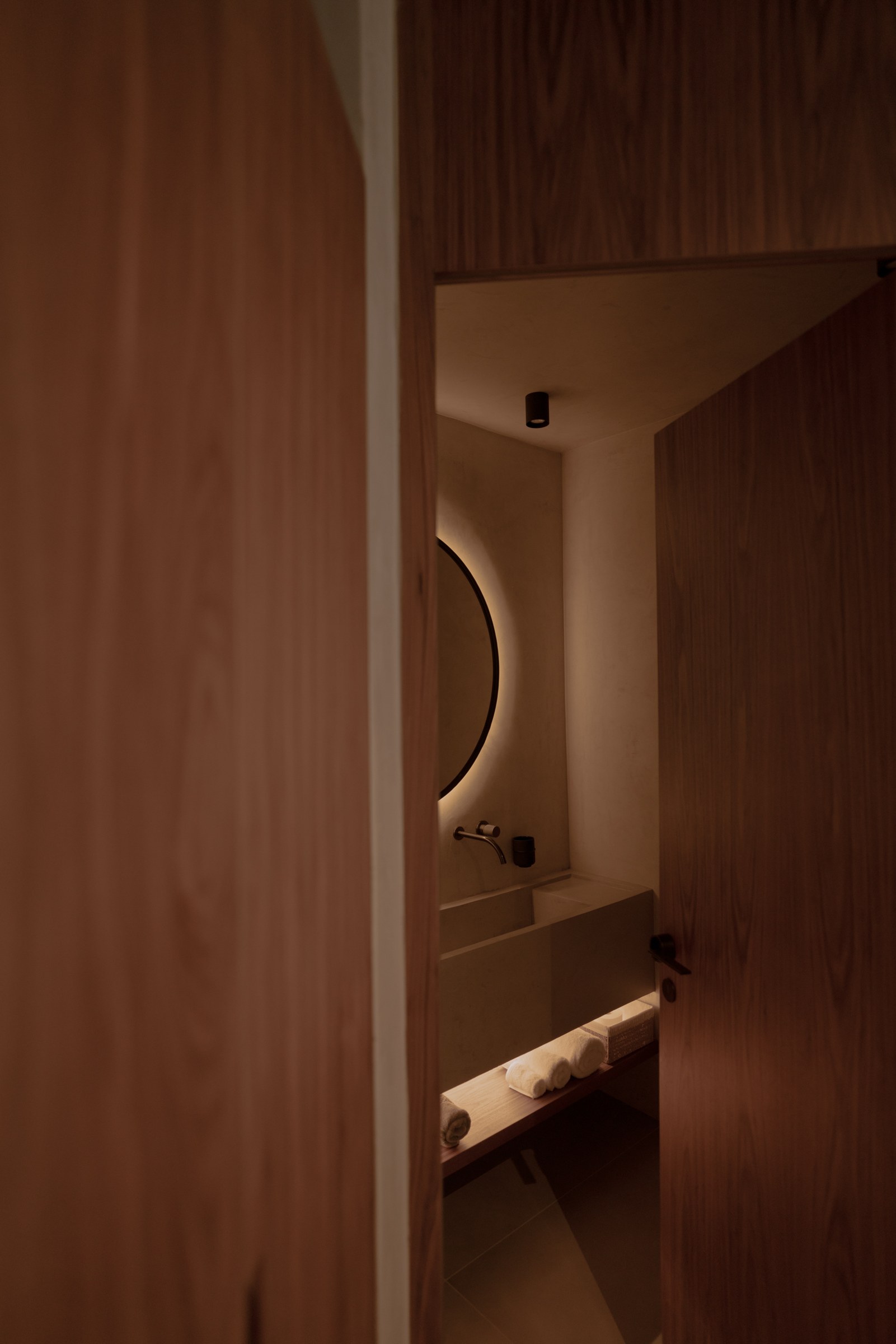 Warm timber and softly illuminated interior detail from the PNOES portfolio